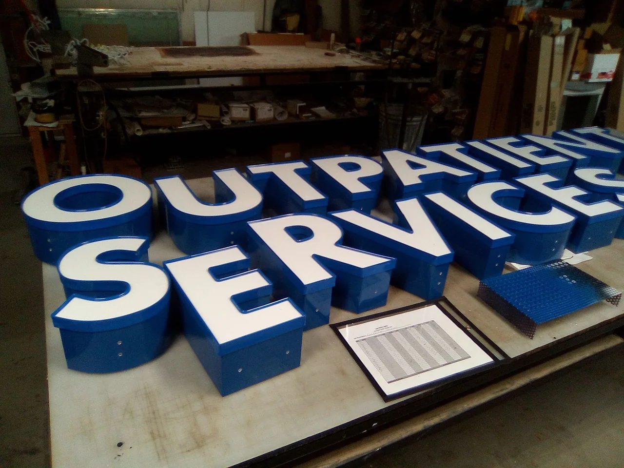 Individual dimensional sign letters laid out on a workshop table