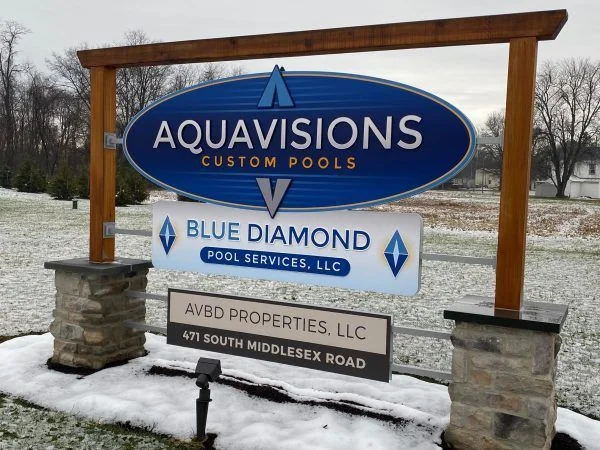 Property entrance sign with an oval business name above separate occupant panels