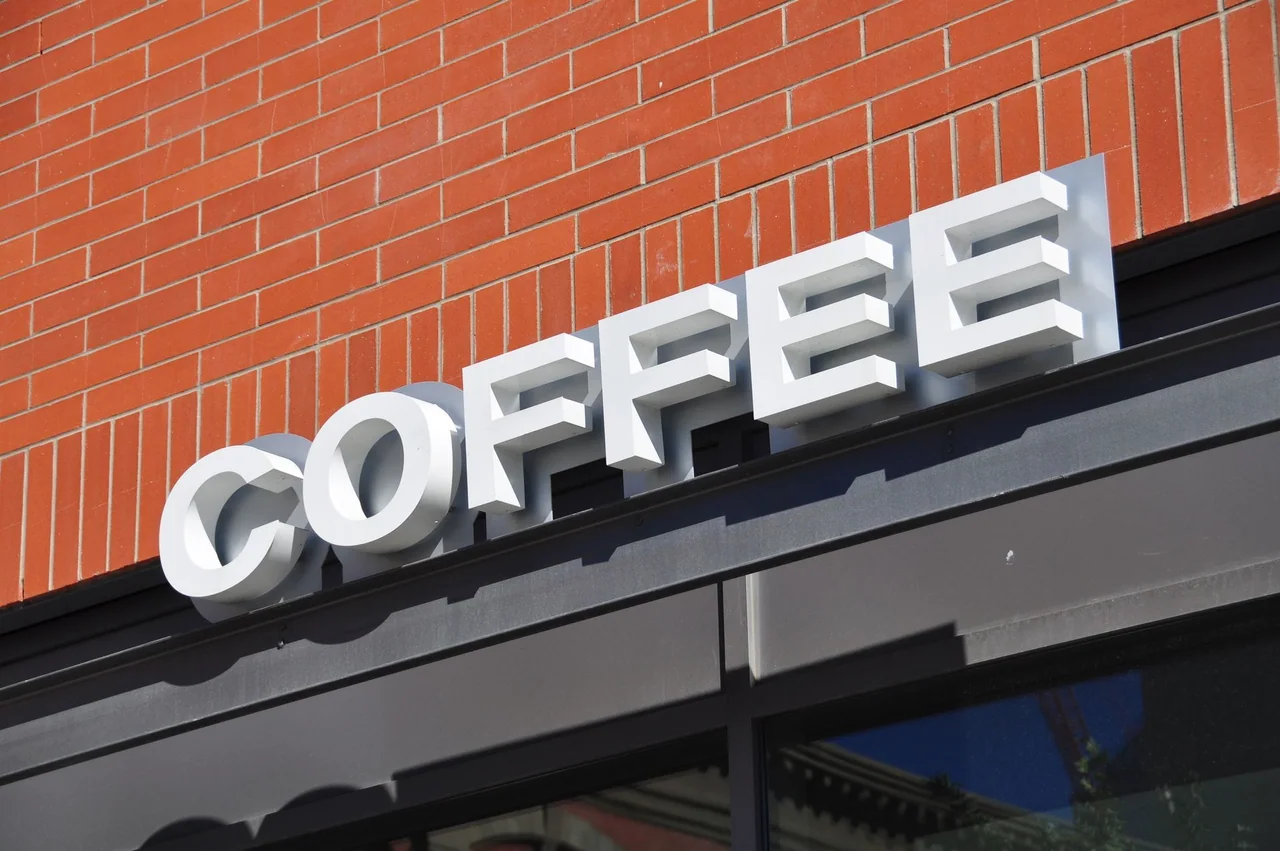 White individual channel letters spelling COFFEE on a brick building