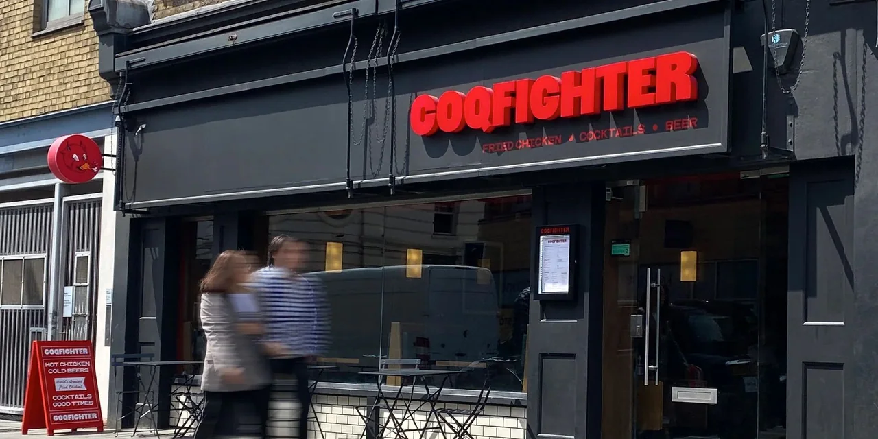 Red illuminated restaurant letters above a dark storefront
